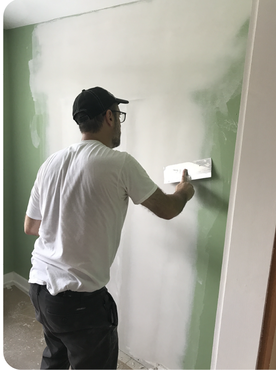Drywall professional applying joint compound to repair wall after HVAC system work, smoothing seams for a seamless finish.